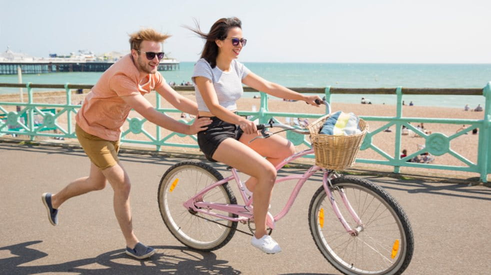 couple riding bike by the beach